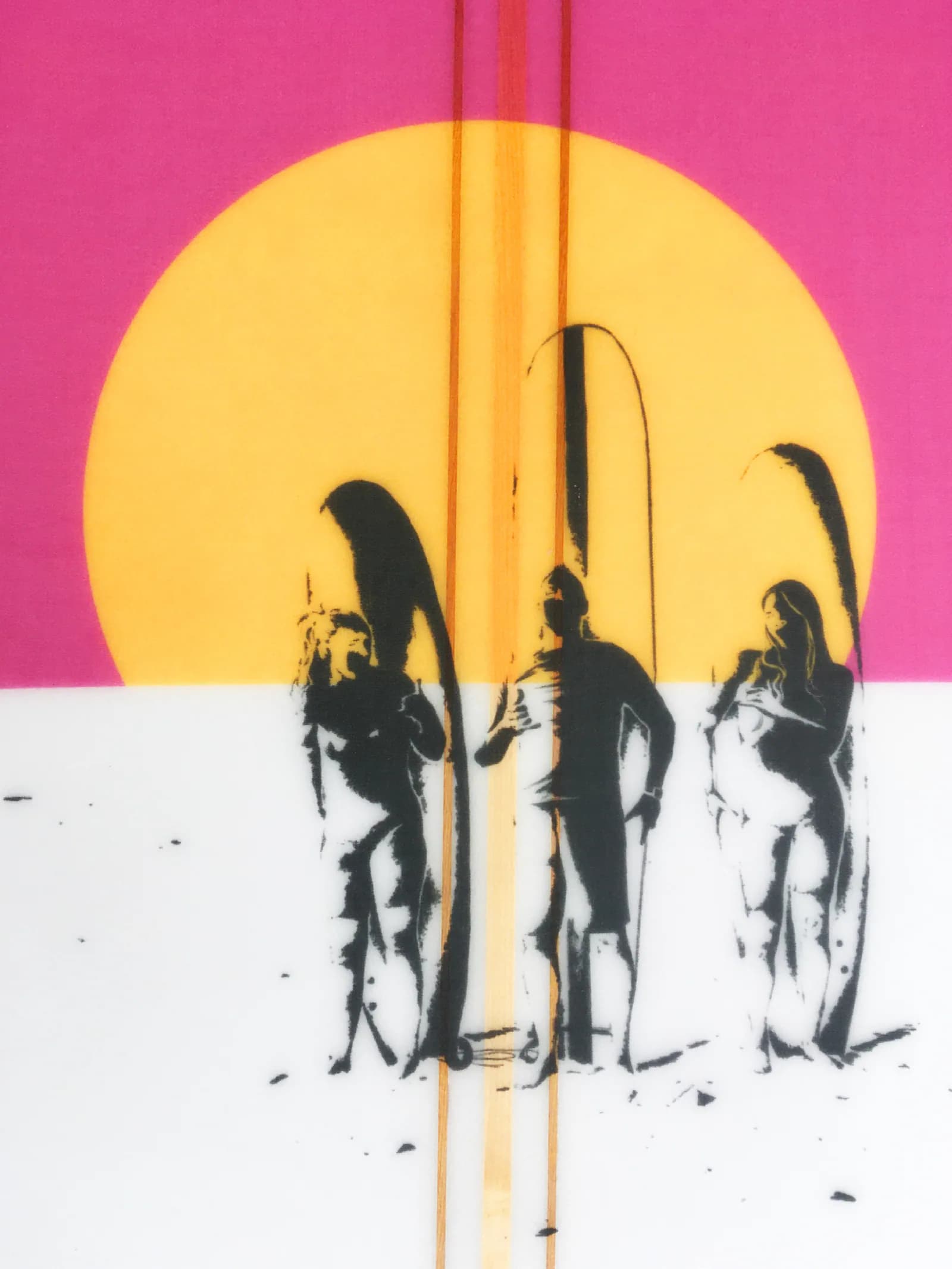 Gros plan sur le soleil jaune orangé et trois silhouettes noires de surfeurs debout avec leurs longboards, traversés par les baguettes de bois
