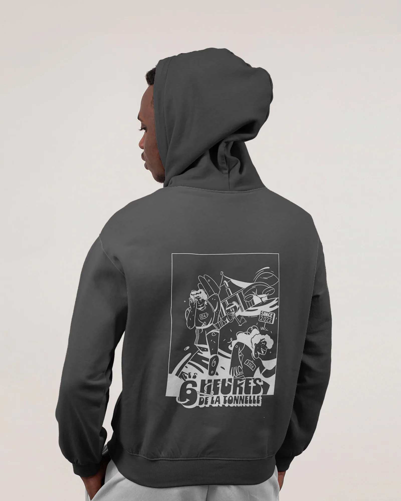 Maquette du sweat à capuche gris foncé porté de dos, avec l’illustration des 6 Heures de la Tonnelle imprimée en blanc au centre du dos.